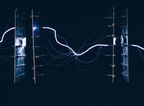 A closeup shot of electrical chipsets transmitting energy through each other on a dark background